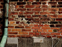 old brick wall with copper pipe